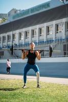 jovem eleva a fasquia no estádio, treino ao ar livre foto