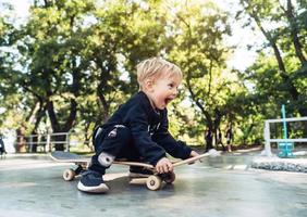 jovem sentado no parque em um skate. foto