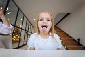 menina com a língua para fora em close-up da câmera foto