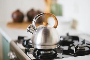 chaleira no fogão a gás. interior da cozinha moderna foto