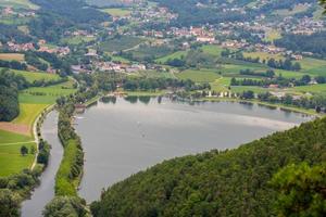 maravilhoso lago na natureza verde com casas acima foto