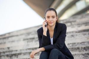 empresária confiante negociando no telefone ao ar livre