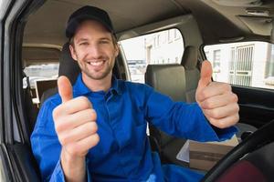 motorista de entrega sorrindo para a câmera em sua van