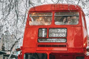 amoroso jovem casal se diverte no ônibus vermelho foto