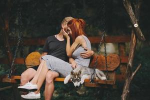 lindo casal junto com cachorro em um balanço foto