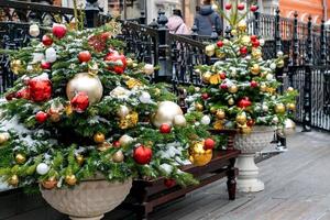 close-up de decoração de árvores de natal com brinquedos e guirlandas. decoração festiva da cidade durante as férias de inverno foto