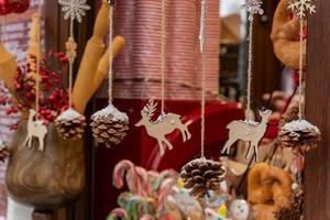 close-up de guirlanda de materiais naturais. estatuetas de madeira e pinhas em um cordão. decoração de natal estilo eco foto
