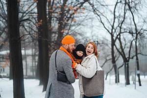 pai mãe e bebê no parque no inverno foto