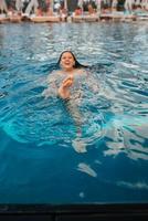 jovem nadador na água azul da piscina foto