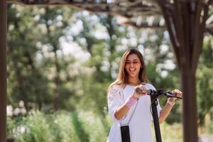 jovem mulher bonita provocando e mostrando a língua na câmera no parque foto