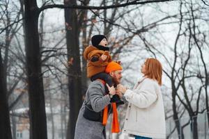 pai mãe e bebê no parque no inverno foto