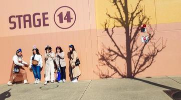 osaka, japão, em 9 de abril de 2019. cinco melhores amigos asiáticos estão tirando fotos em frente à fachada do palco 14 do estúdio universal japão.