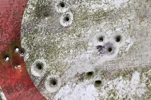 close-up detalhado de buracos de bala de tiros em um sinal de trânsito foto