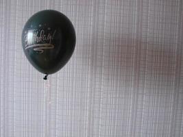 balão preto com palavras feliz aniversário em fundo amarelo, espaço para texto foto