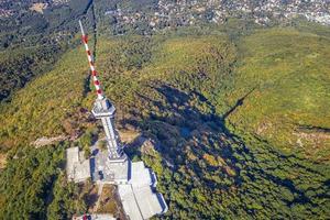 vista aérea superior em uma torre de transmissão em uma colina de montanha e cidade. um conceito de comunicação. foto