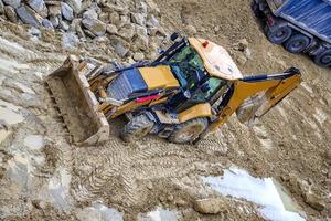 bulldozer amarelo em solo de barro no canteiro de obras industrial foto