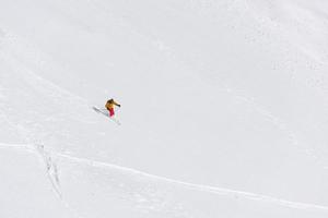 esquiador freeride esquiando na neve em pó profundo foto