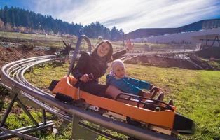 Suécia, 2022 - jovem mãe e filho dirigindo montanha-russa alpina foto