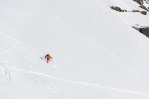 esquiador freeride esquiando na neve em pó profundo foto