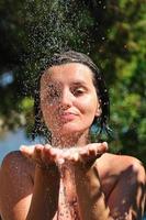 jovem mulher bonita relaxante sob o chuveiro foto