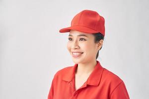 mulher de entrega sorridente em uniforme vermelho em pé com o braço cruzado - isolado no fundo branco foto