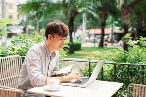 jovem sorridente usando laptop para atribuição de trabalho