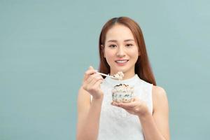 alimentos saudáveis para perda de peso. jovem comendo iogurte, passas e aveia foto