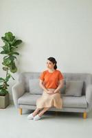 mulher bonita em roupas casuais, sentado em um sofá foto