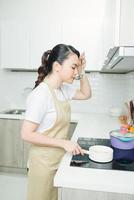 jovem de pé ao lado do fogão na cozinha. foto