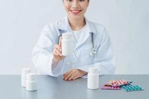 bela médica médica ou farmacêutico sentado na mesa de trabalho foto