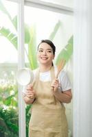 jovem vestindo avental de cozinha com panela foto