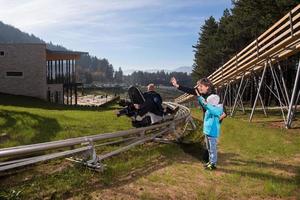 Suécia, 2022 - família feliz dirigindo na montanha-russa alpina foto