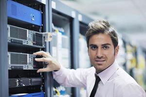 jovem engenheiro de TI na sala do servidor de datacenter foto