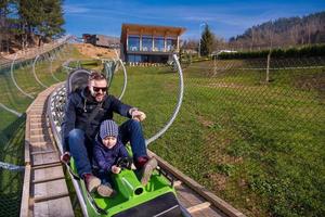 croácia, 2022 - jovem pai e filho dirigindo montanha-russa alpina foto