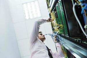 jovem engenheiro de TI na sala do servidor do datacenter foto