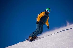 snowboarder descendo a ladeira e andar de estilo livre foto