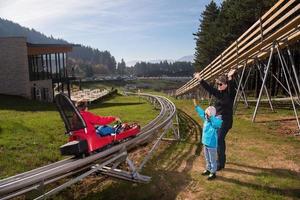 Suécia, 2022 - família feliz dirigindo na montanha-russa alpina foto