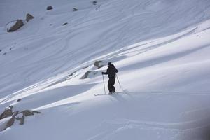 esquiador freeride esquiando na neve em pó profundo foto
