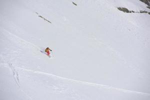 esquiador freeride esquiando na neve em pó profundo foto