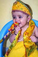 lindo garoto indiano vestido como pequeno senhor krishna por ocasião do festival radha krishna janmastami em delhi índia foto