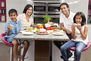 família de crianças asiáticas pais indianos comer comida saudável na cozinha