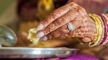 mãos da noiva indiana comendo foto