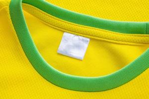 etiqueta de roupas têxteis em branco em branco na textura de jersey de tecido de roupas esportivas amarelas foto
