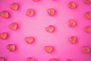 fundo de dia dos namorados com doces de forma de coração no fundo rosa