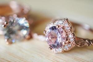 anéis de safira rosa de joias em fundo de madeira foto