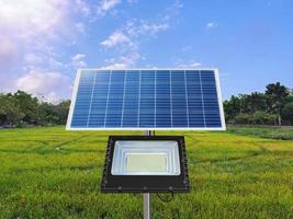 um holofote fotovoltaico usa energia solar no meio de um campo de arroz. conceito de energia pura foto