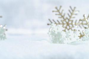 natal de inverno - bolas de natal com fita na neve, conceito de férias de inverno. bolas vermelhas de natal, bolas douradas, decorações de pinho e flocos de neve em fundo de neve foto