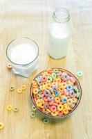 tigela de cereal infantil colorido e leite isolado na mesa de madeira com espaço de texto foto