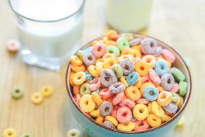 tigela de cereal infantil colorido e leite isolado na mesa de madeira com espaço de texto foto