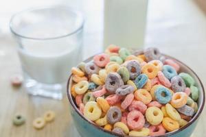 tigela de cereal infantil colorido e leite isolado na mesa de madeira com espaço de texto foto